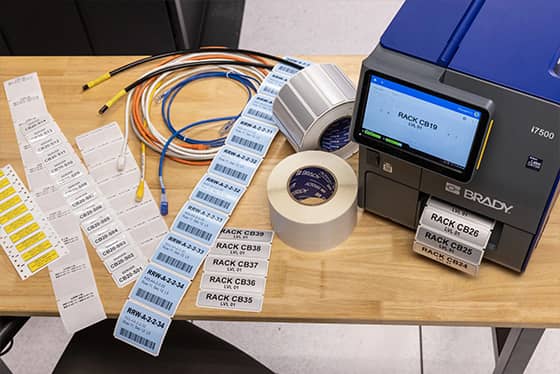 Een werknemer brengt een eigendomslabel aan op een laptop.