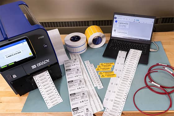 Een werknemer brengt een eigendomslabel aan op een laptop.